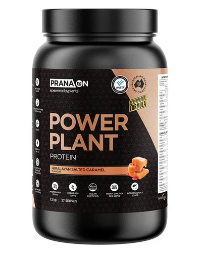 A container of Prana On Power Plant Protein powder in caramel flavor. The packaging is black with gold and white text and an image of a caramel.