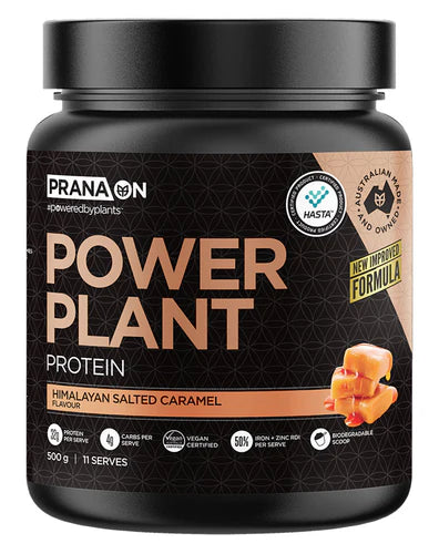 A container of Prana On Power Plant Protein powder in caramel flavor. The packaging is black with gold and white text and an image of a chocolate bar.